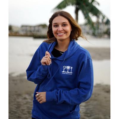 Girl vacactioning on palm tree island in Wrightsville Beach in Blue Hoodie